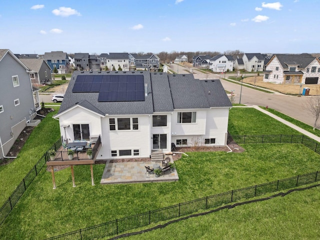 rear view of property featuring a residential view, a patio, and a fenced backyard
