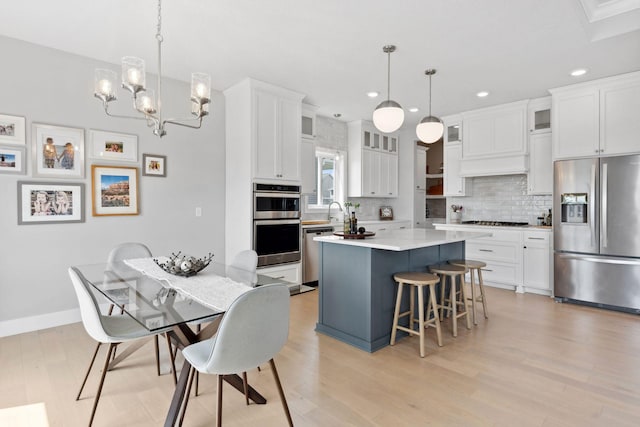 kitchen with a breakfast bar, stainless steel appliances, a center island, recessed lighting, and backsplash