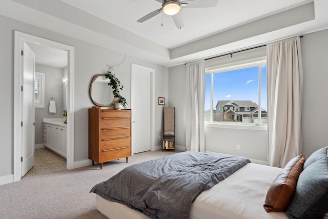 bedroom featuring connected bathroom, a ceiling fan, light colored carpet, and baseboards