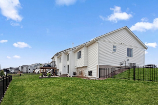 back of property featuring a wooden deck, a fenced backyard, cooling unit, and a lawn