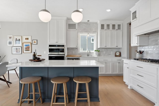 kitchen featuring a center island, a kitchen breakfast bar, white cabinets, and appliances with stainless steel finishes