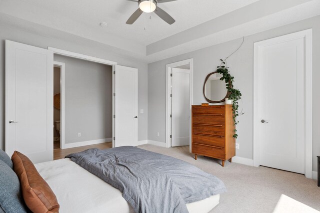 bedroom with baseboards, a ceiling fan, and light carpet
