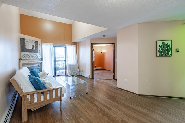 living room with baseboard heating, baseboards, a baseboard heating unit, and wood finished floors