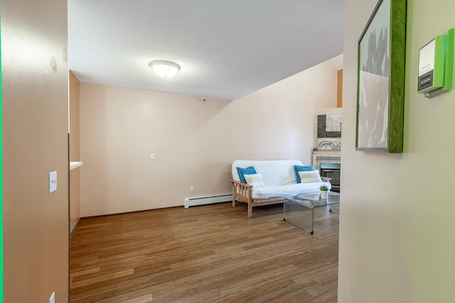 sitting room with baseboard heating and wood finished floors