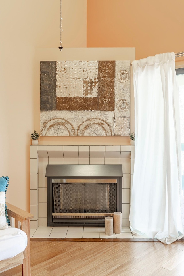 room details with a tile fireplace and wood finished floors