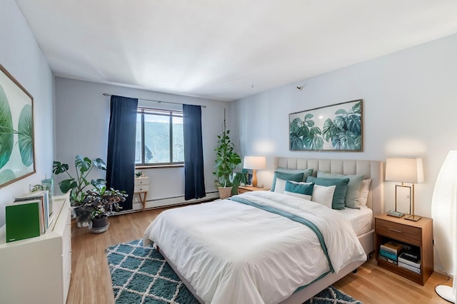 bedroom featuring light wood-style floors and a baseboard radiator