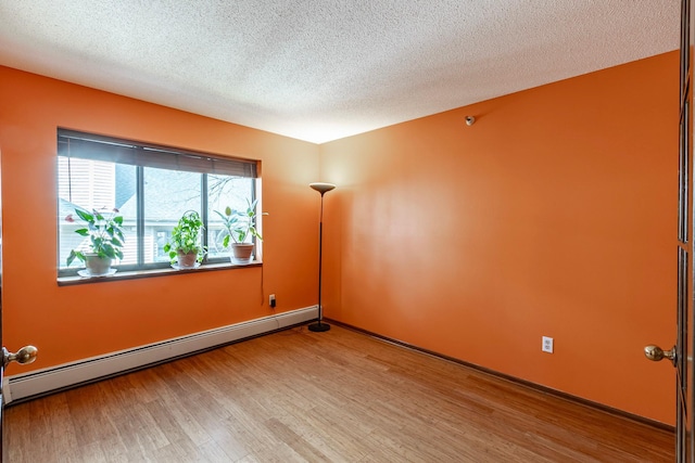 7631 Edinborough Way Unit 5319, Edina, MN 55435 - empty room featuring a baseboard heating unit, wood finished floors, and a textured ceiling