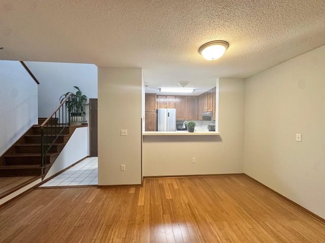 7631 Edinborough Way Unit 5319, Edina, MN 55435 - unfurnished living room with light wood-style flooring, stairs, and a textured ceiling