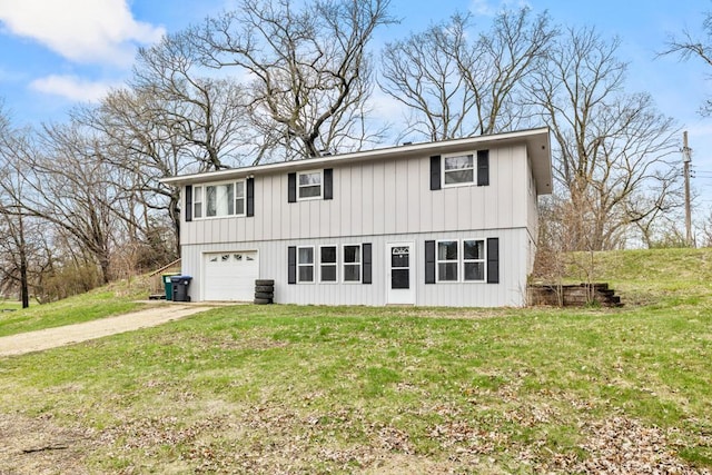 view of front of house with a front yard, dirt driveway, and an attached garage
