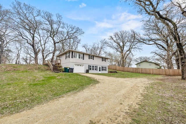 view of front of home featuring stairway, fence, a garage, driveway, and a front lawn