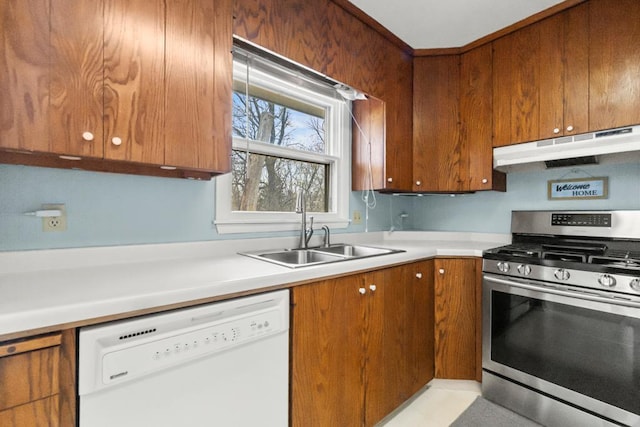 kitchen with stainless steel range with gas cooktop, a sink, white dishwasher, under cabinet range hood, and brown cabinetry