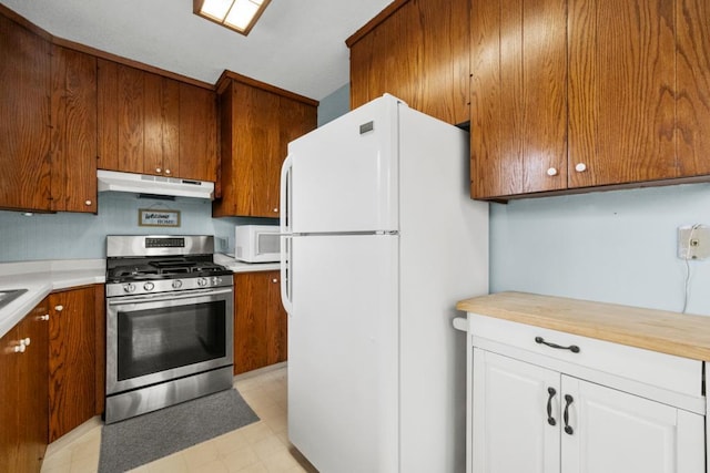 kitchen with light floors, white appliances, under cabinet range hood, and brown cabinetry