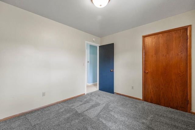 unfurnished bedroom with carpet flooring and baseboards
