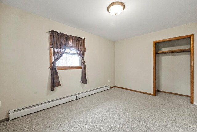 unfurnished bedroom with baseboards, light carpet, a closet, and a baseboard radiator