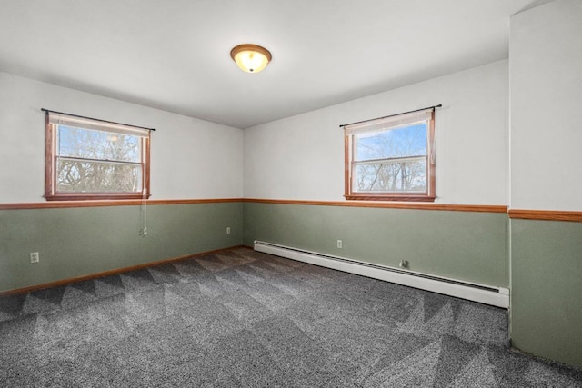 empty room featuring carpet, baseboard heating, and baseboards