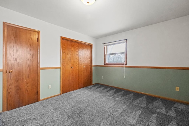 unfurnished bedroom featuring a closet, carpet floors, and baseboards