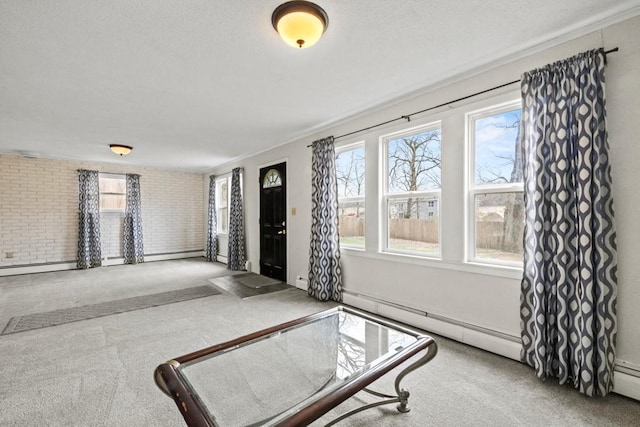 interior space with brick wall, baseboard heating, and carpet floors