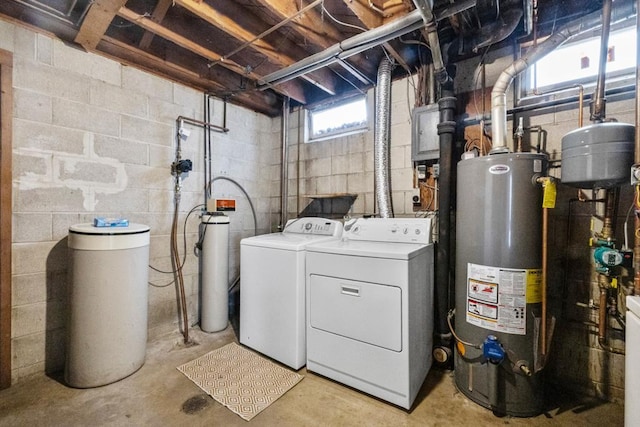 clothes washing area featuring water heater, laundry area, and washer and clothes dryer