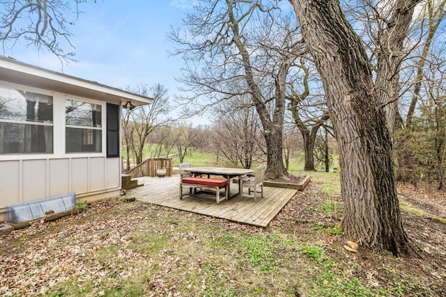 view of yard featuring a wooden deck and outdoor dining space