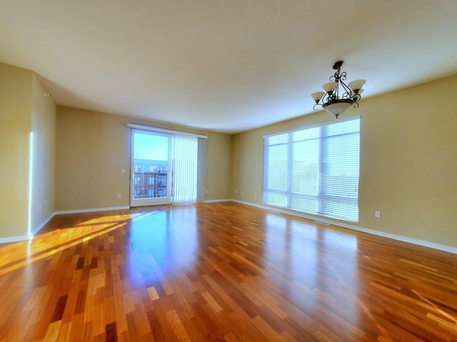 1070 Grandview Ct NE Unit 413, Columbia Heights, MN 55421 - empty room featuring an inviting chandelier, wood finished floors, and baseboards