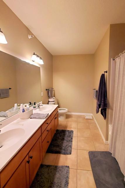 1070 Grandview Ct NE Unit 413, Columbia Heights, MN 55421 - full bathroom featuring toilet, tile patterned floors, double vanity, and a sink
