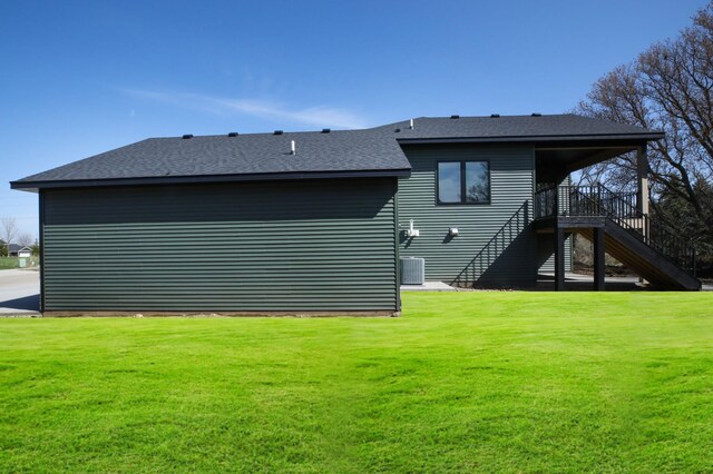 1504 14th Ave NE, Kasson, MN 55944 - back of house featuring stairs, a yard, roof with shingles, and central air condition unit