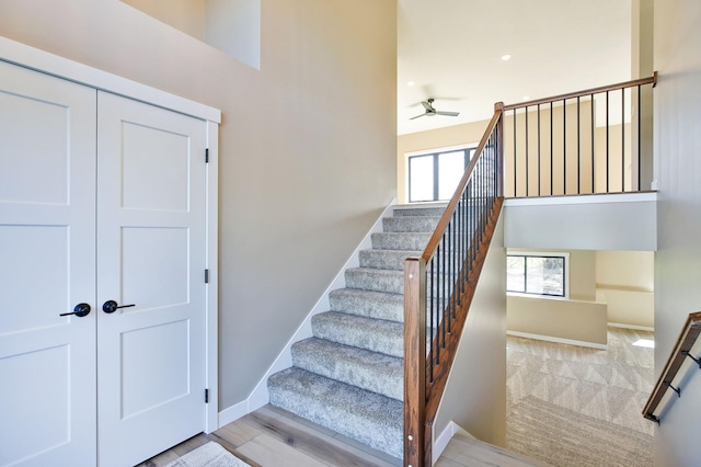 1504 14th Ave NE, Kasson, MN 55944 - stairway with a ceiling fan, baseboards, a towering ceiling, and wood finished floors