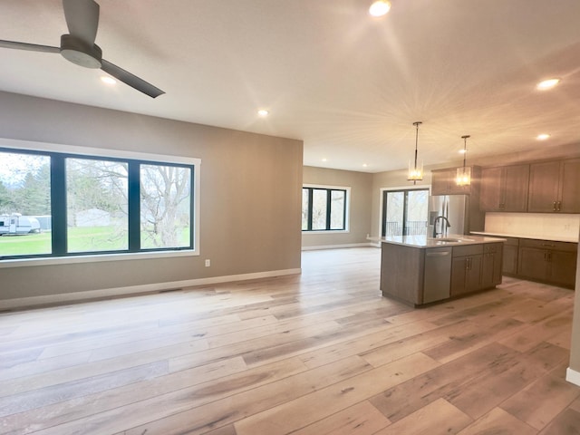 1504 14th Ave NE, Kasson, MN 55944 - kitchen featuring open floor plan, light wood-style flooring, a ceiling fan, light countertops, and an island with sink