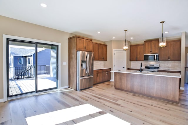 1504 14th Ave NE, Kasson, MN 55944 - kitchen featuring appliances with stainless steel finishes, light wood finished floors, a chandelier, light countertops, and decorative backsplash