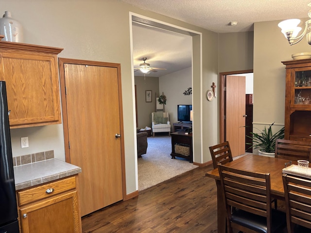 154 Pond Dr, Jackson, MN 56143 - dining space featuring a textured ceiling, ceiling fan with notable chandelier, and dark wood finished floors