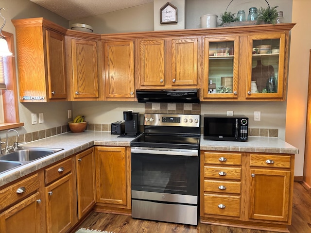 154 Pond Dr, Jackson, MN 56143 - kitchen featuring black microwave, stainless steel range with electric stovetop, light countertops, extractor fan, and dark wood-style floors