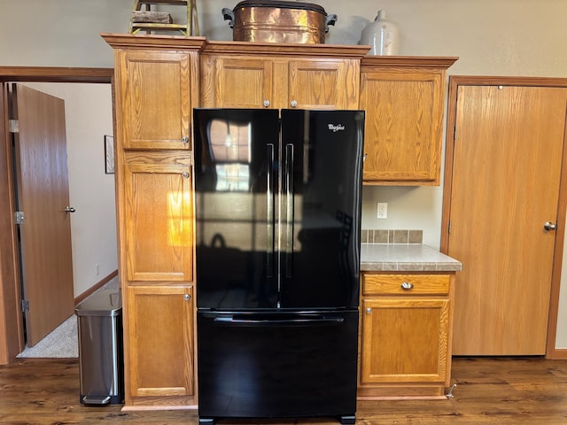 154 Pond Dr, Jackson, MN 56143 - kitchen featuring brown cabinetry, freestanding refrigerator, light countertops, and dark wood-style floors