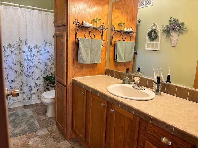 154 Pond Dr, Jackson, MN 56143 - bathroom featuring stone finish floor, vanity, visible vents, and toilet