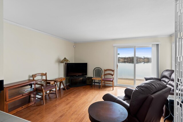living area with ornamental molding and light wood-style floors
