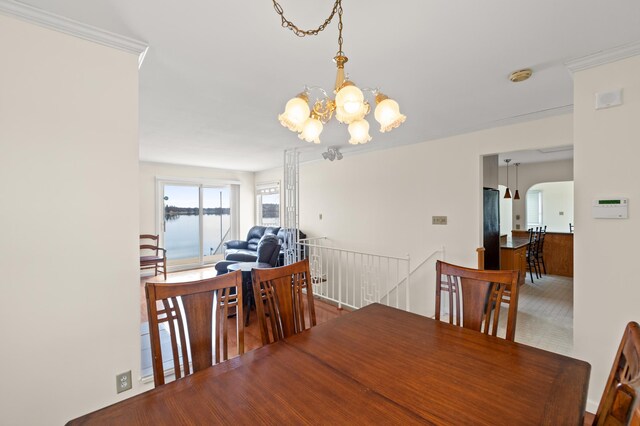 dining area with a chandelier and ornamental molding