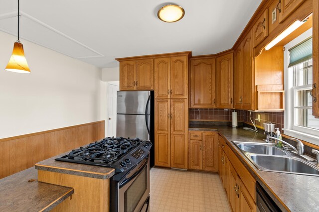 kitchen with light floors, brown cabinets, stainless steel appliances, and a sink