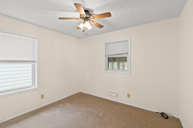 carpeted empty room with baseboards and a ceiling fan