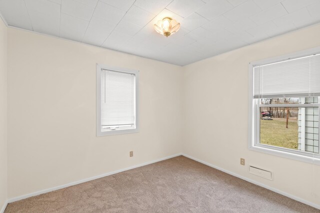 carpeted spare room featuring baseboards