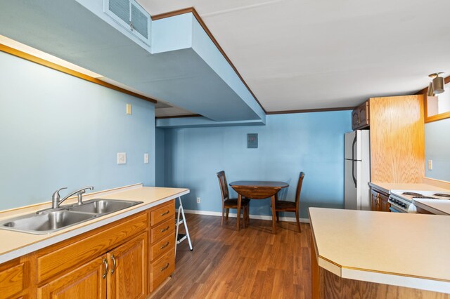 kitchen with brown cabinets, dark wood finished floors, visible vents, a sink, and white appliances