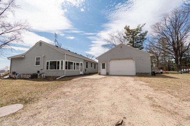 rear view of house with an outbuilding, dirt driveway, and a garage