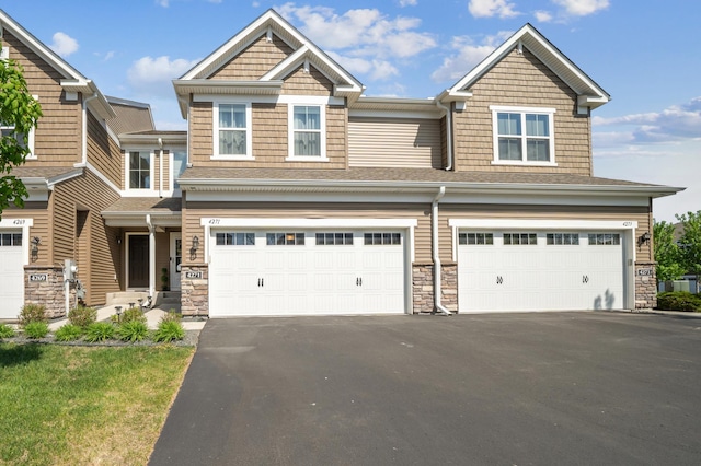 4271 Corn Silk Ln, Woodbury, MN 55129 - view of front of house featuring an attached garage, asphalt driveway, stone siding, and a shingled roof