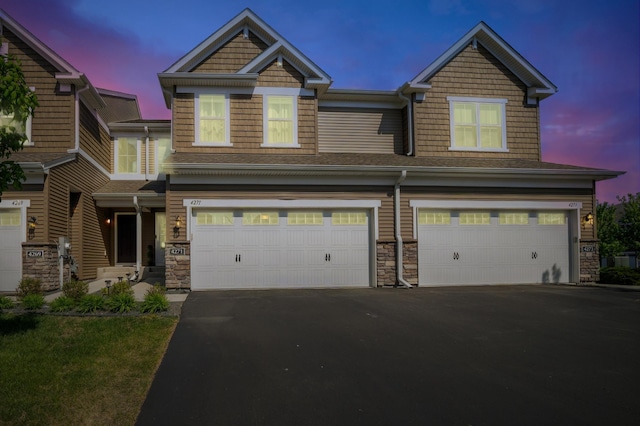 4271 Corn Silk Ln, Woodbury, MN 55129 - view of front of house featuring a garage, driveway, stone siding, and a shingled roof