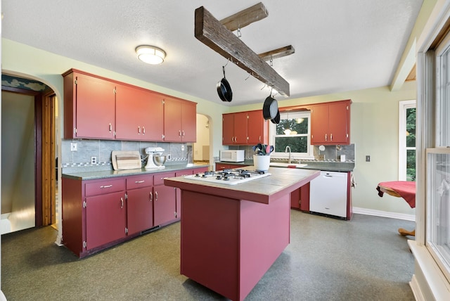 16985 Homestead Rd, Carver, MN 55315 - kitchen with white appliances, red cabinetry, arched walkways, backsplash, and a center island