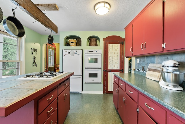 16985 Homestead Rd, Carver, MN 55315 - kitchen with red cabinets, white appliances, backsplash, a textured ceiling, and arched walkways