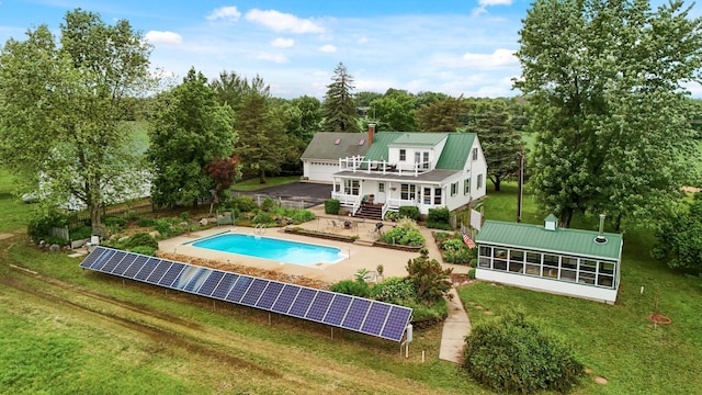 16985 Homestead Rd, Carver, MN 55315 - rear view of house with solar panels, a metal roof, a lawn, and an outdoor pool