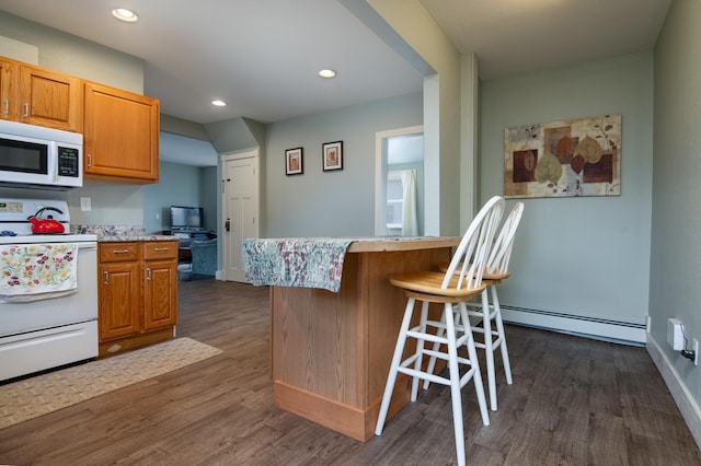 311 Prairie St, Lake City, MN 55041 - kitchen with a baseboard heating unit, dark wood-style floors, white appliances, light countertops, and a breakfast bar area