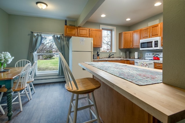 311 Prairie St, Lake City, MN 55041 - kitchen with a baseboard heating unit, dark wood-type flooring, white appliances, and plenty of natural light