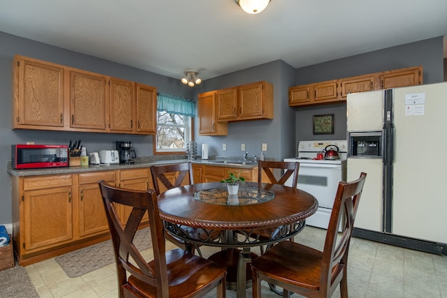 311 Prairie St, Lake City, MN 55041 - kitchen with light floors, brown cabinetry, white appliances, and a sink