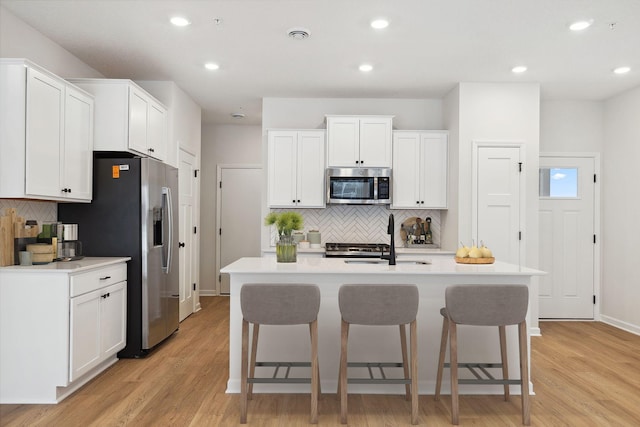 kitchen with decorative backsplash, a breakfast bar area, stainless steel appliances, and a sink