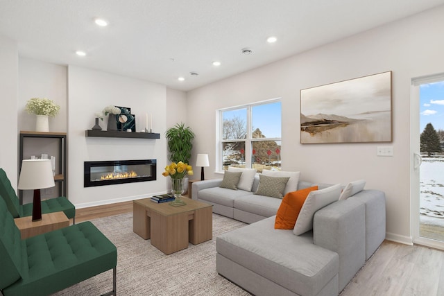 living area featuring light wood-type flooring, a wealth of natural light, and recessed lighting